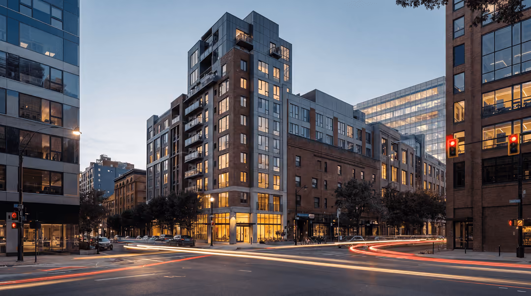 Office and apartment towers at dusk, traffic streaking past